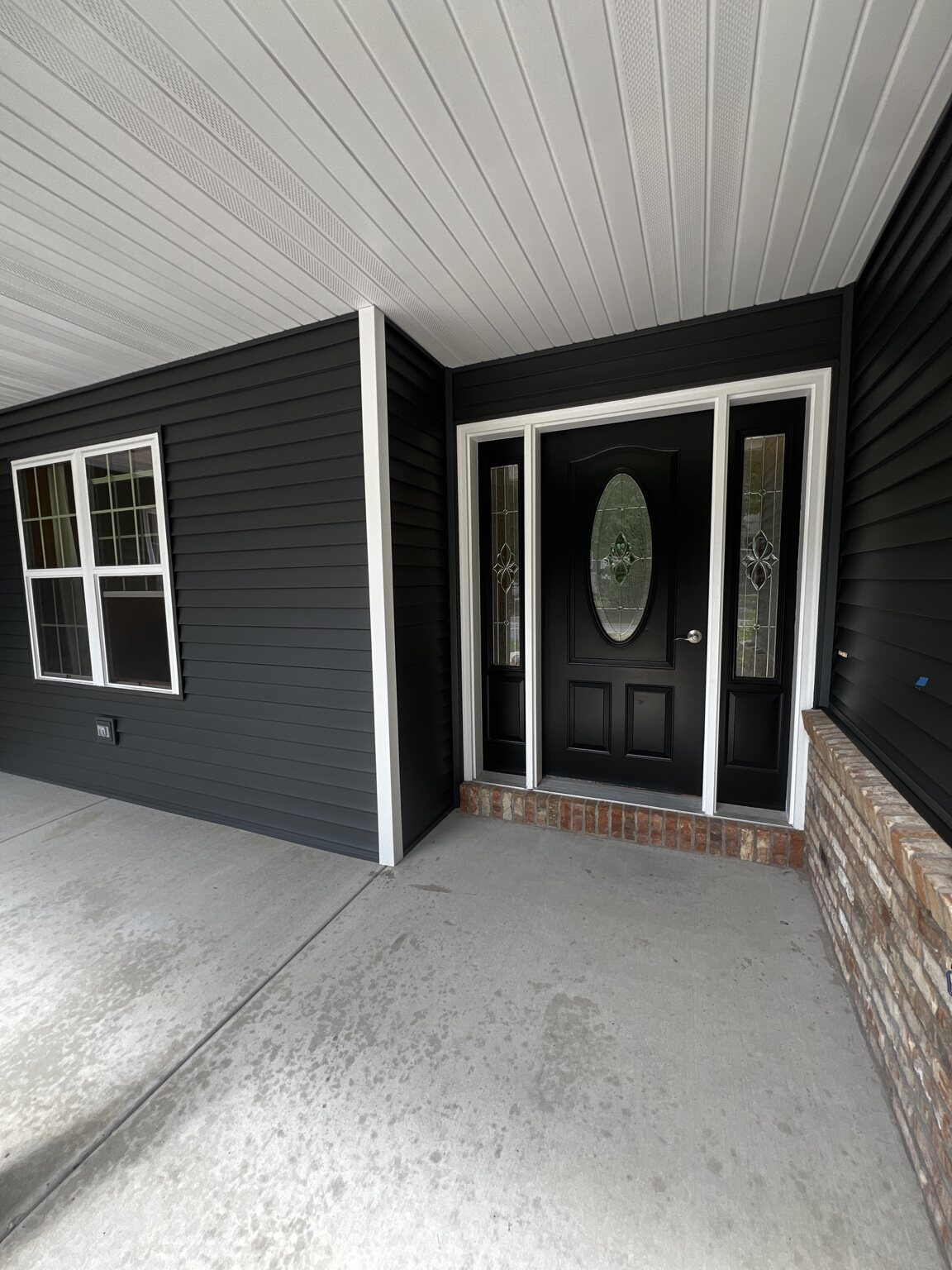 Crisp dark siding and white porch trim